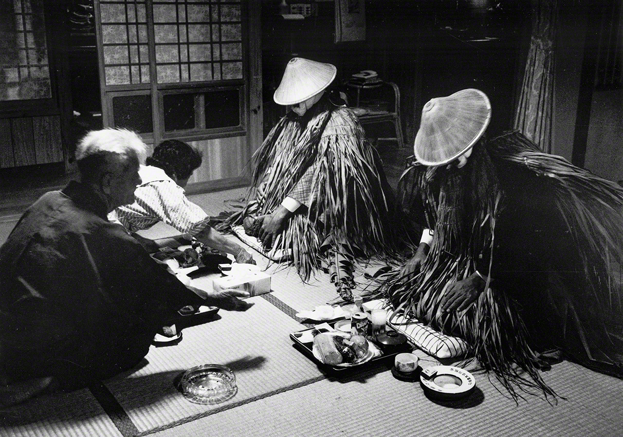 《迎神宴》。这是冲绳县石垣岛川平地区的新年传统活动。村民设宴款待从大海彼岸“尼拉伊”(冲绳民俗中传说的极乐净土)之国而来的神明。画面传递出人与神明密切交流的庄重感(摄于1988年)