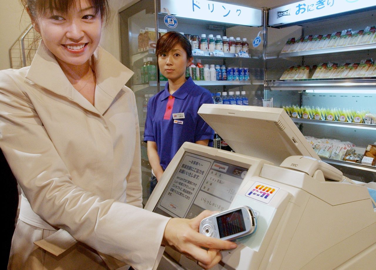 2004年6月16日,NTT Docomo在东京千代田区召开发布会,推出“手机钱包”服务。使用内置非接触式芯片、支持i-Mode的手机,只需贴近收银机即可完成付款(图片:时事社)