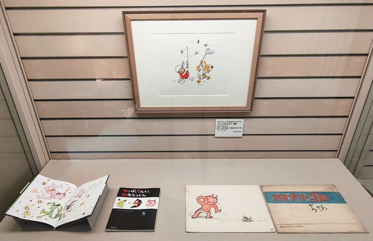 “加古里子诞辰一百周年展”中展出的小达摩相关作品。墙上挂着的是2008年该馆首次举办加古里子展时,加古专门全新绘制的海报原画