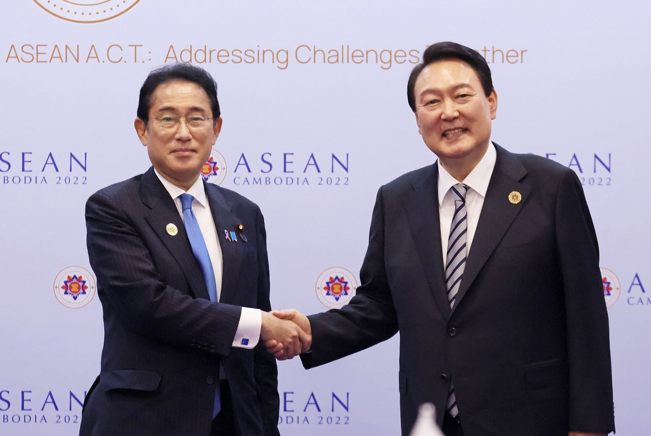 首相岸田文雄（左）与韩国总统尹锡悦握手，2022年11月13日，柬埔寨金边（内阁广报室提供，时事社）