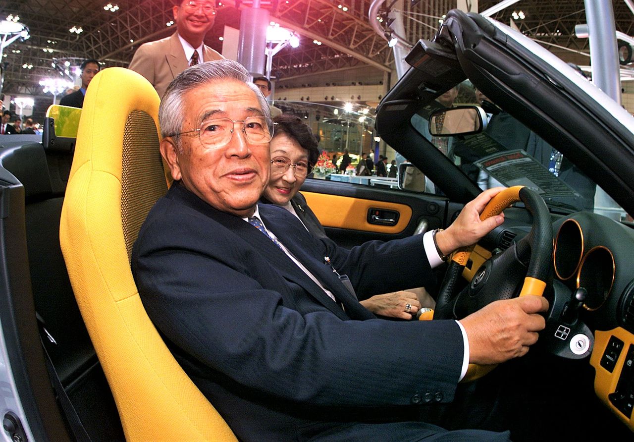 1999年10月的东京国际车展上，丰田章一郎坐在丰田MR-S的驾驶位上手握方向盘（AFP/时事社）