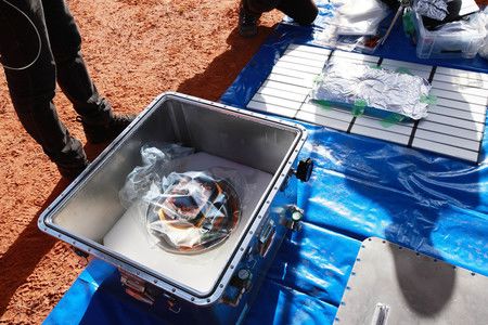 在澳南部沙漠回收后，“隼鸟2号”探测器样本舱被装入集装箱，6日（JAXA提供）
