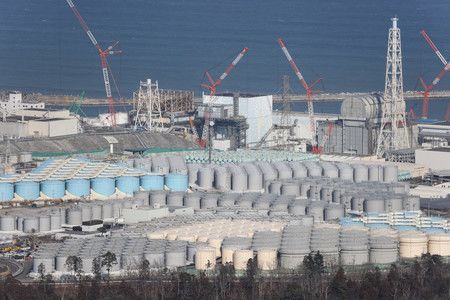 正在进行废炉工作的东京电力福岛第一核电站内，存放着大量装有核污处理水的水箱(前方)， 2月14日，福岛县（摄自时事社包机）