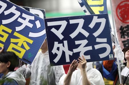 反对者们高举标语牌游行示威，抗议政府的防控疫情对策，6月19日于东京都渋谷区