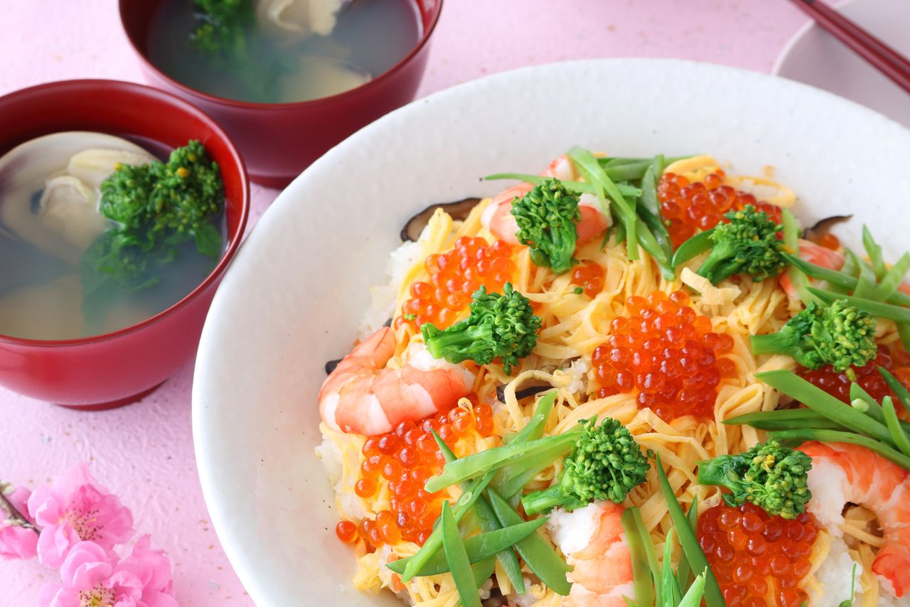 Hinamatsuri dishes: (Top) Clam soup, at left, with chirashizushi; (bottom) clockwise from left, hishimochi, shirozake, and hinaarare. (© Pixta)