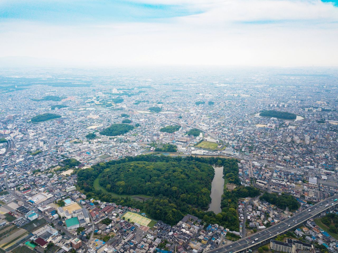 This aerial photo shows the highly built up area surrounding the Furuichi Tumulus cluster. The tomb of of Emperor Ōjin can be seen at the bottom center of the frame.