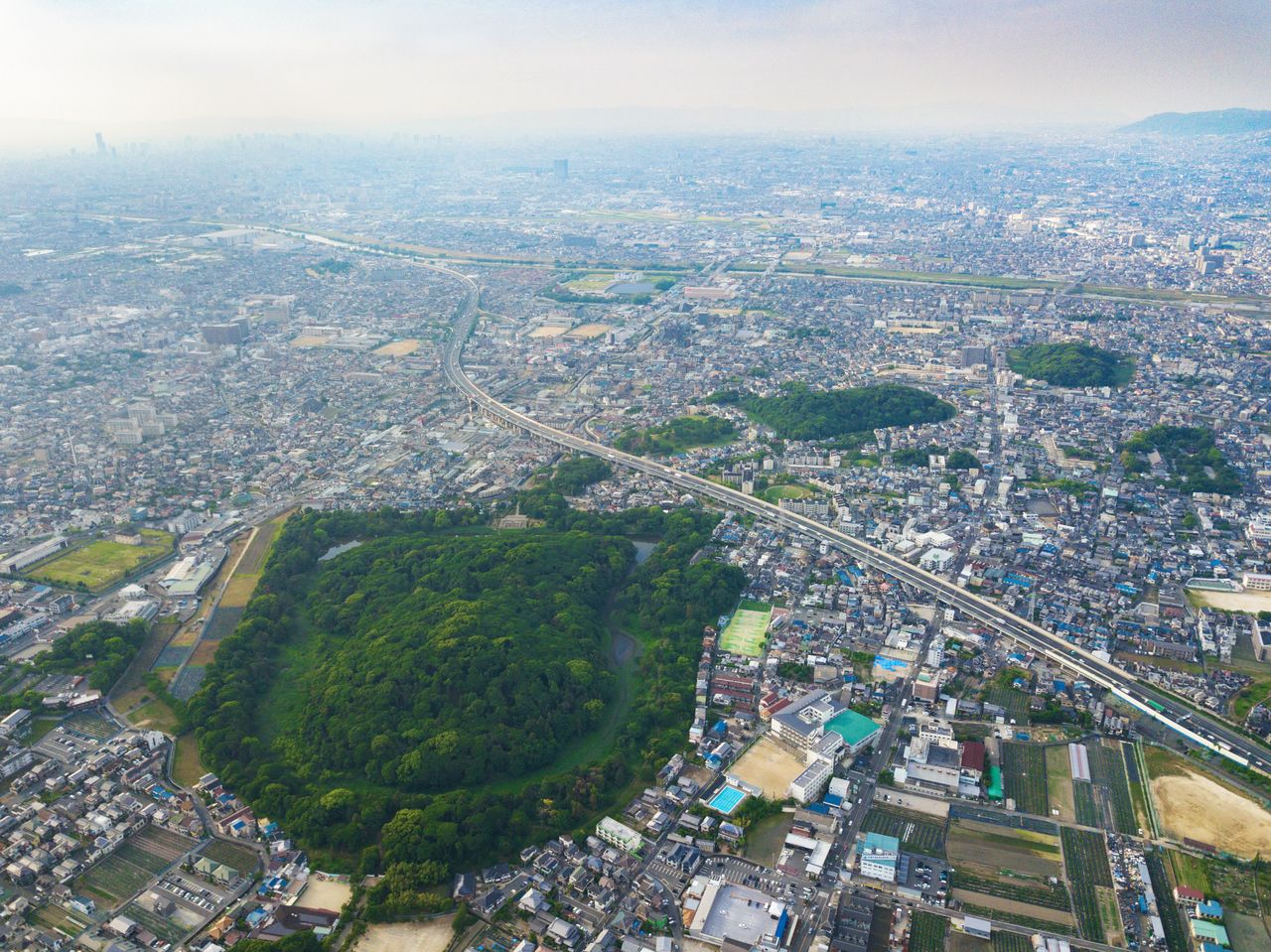 The burial mounds form a “tail” that stretches from the tomb of Emperor Ōjin, in the foreground, to the upper right of the photo.