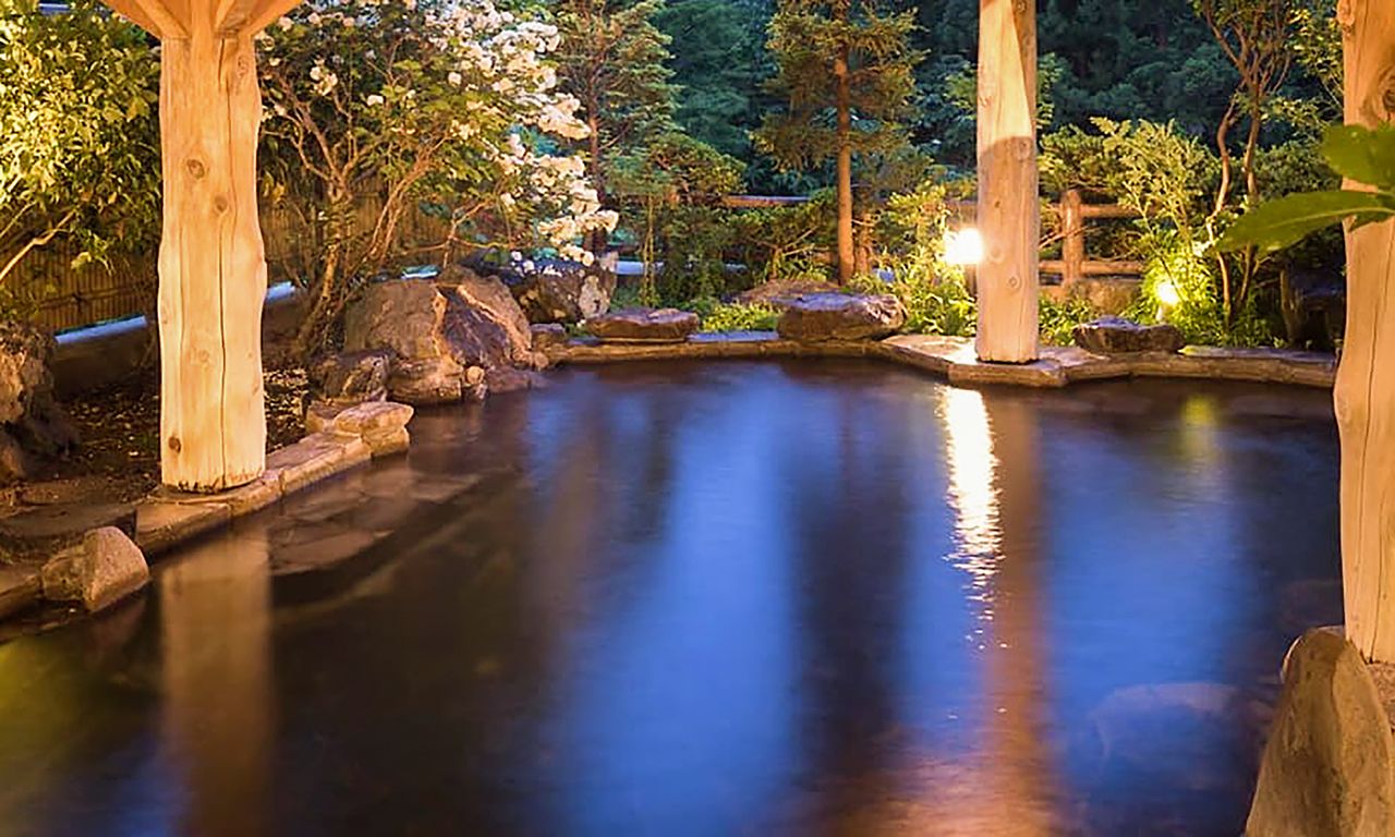 The outdoor bath at Hotel Kōyōkan is floodlit by night, lending it a surreal atmosphere. (Courtesy  Hanamakionsen Co., Ltd.)