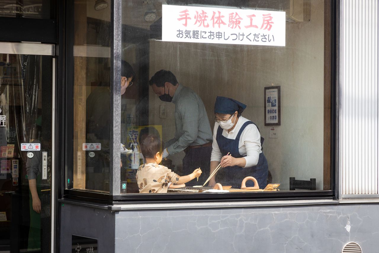 A large window invites curious passersby of all ages to watch the senbei-making action—or to step in and give it a try.