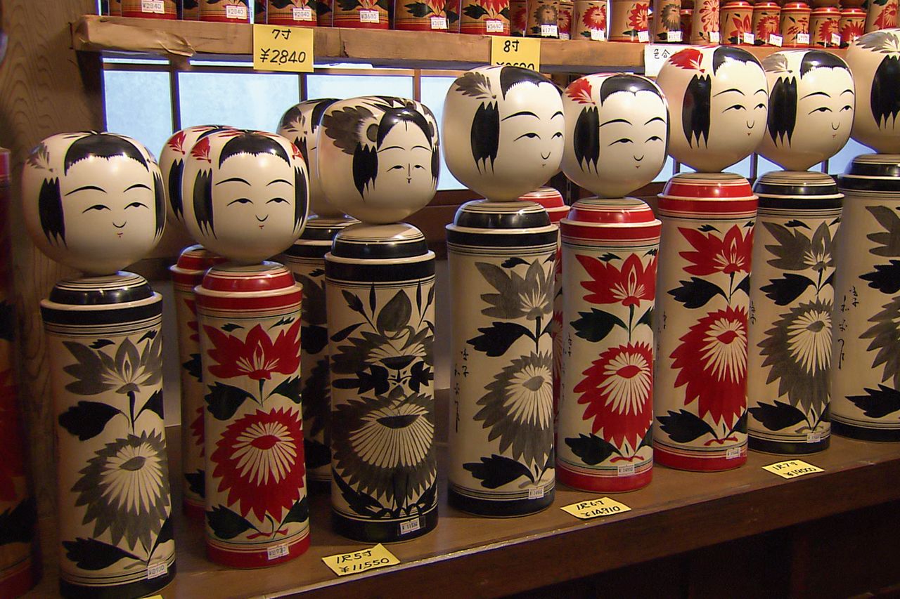 Seen from the front, Naruko Onsen kokeshi display a line of chrysanthemums, while their heads are crowned with lozenge-shaped chrysanthemum crests. (Photo courtesy of the Miyagi Prefectural Tourism Department)