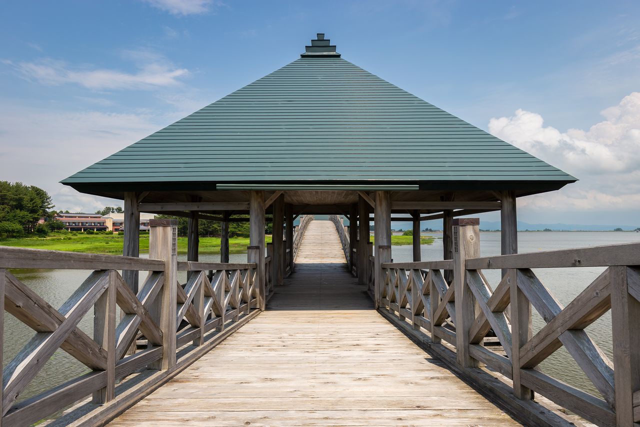 A covered rest area on the bridge where visitors can take in the surrounding beauty.