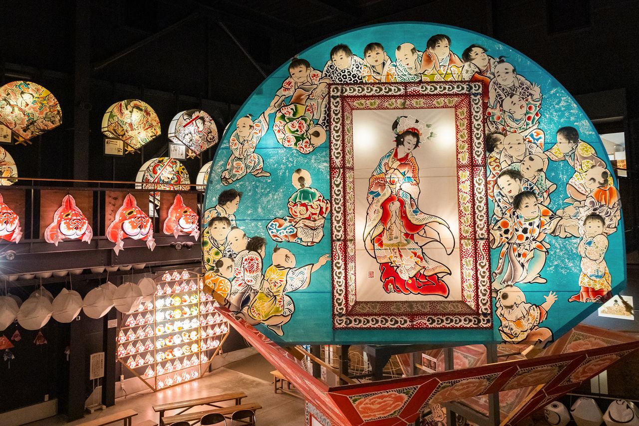 A float in mid turn reveals the okuri-e of a classical beauty painted on the reverse side.