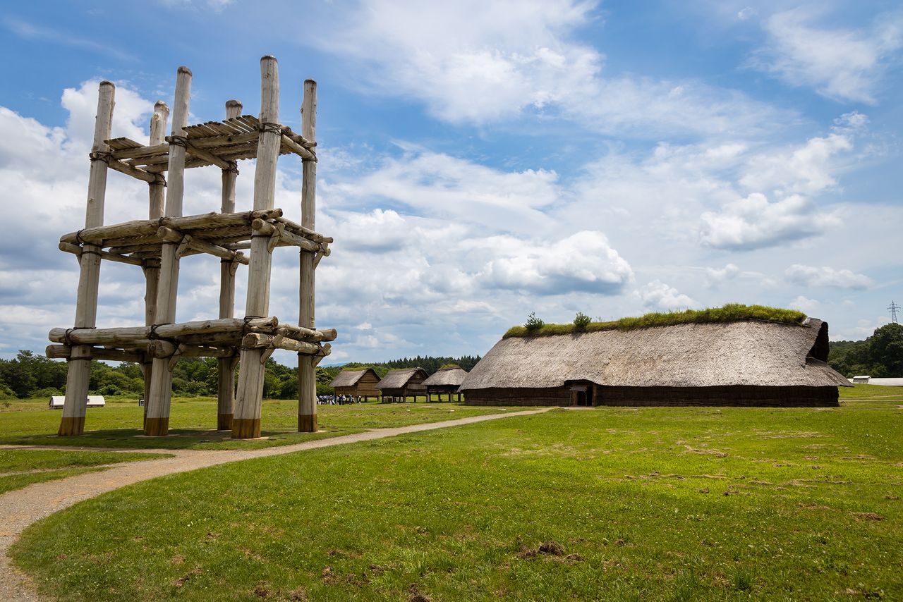 A towering pillar-supported structure, left, and reconstructed pit dwelling have come to symbolize the Sannai Maruyama site.