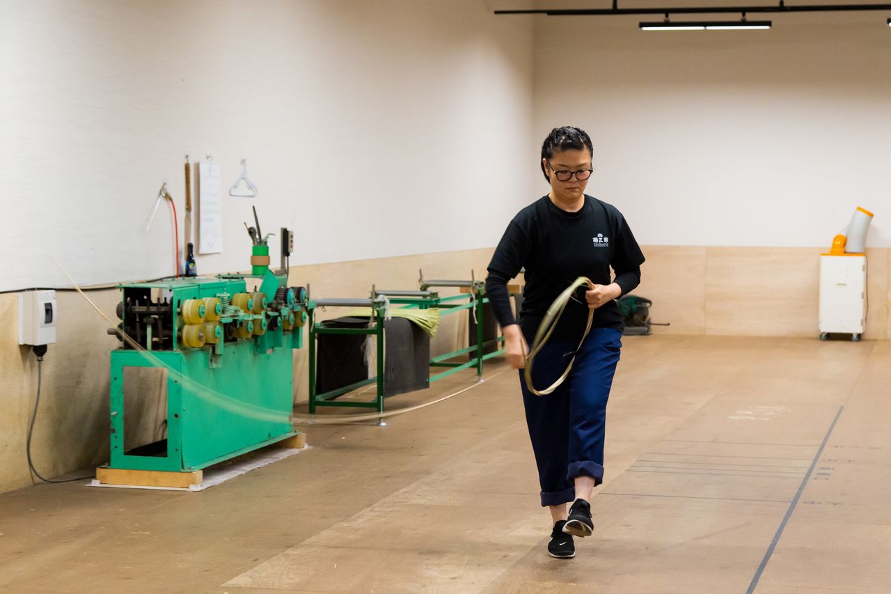 With dance-like movements, trainee Arai Chika demonstrates how to wind the bamboo for making a barrel hoop.