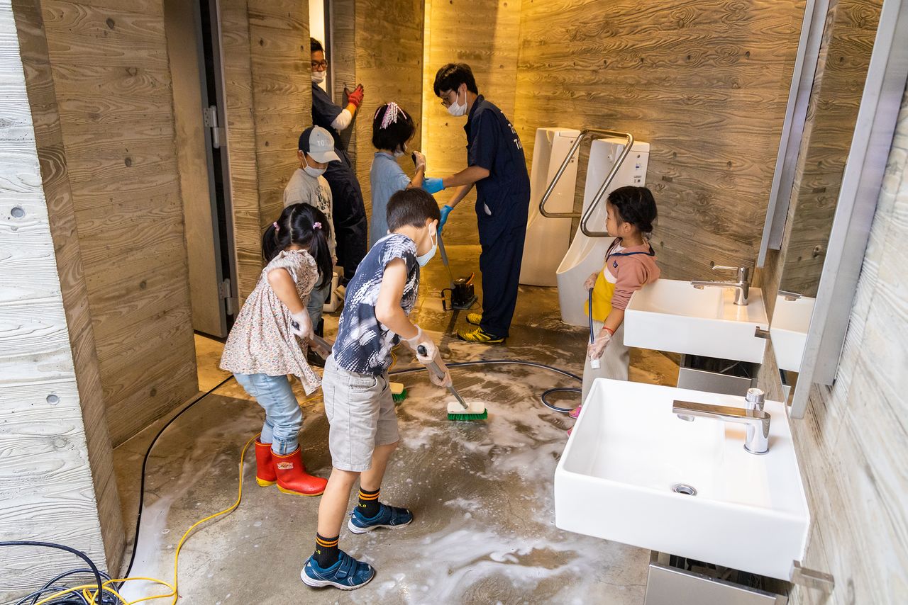 Children hard at work scrubbing toilet floors.