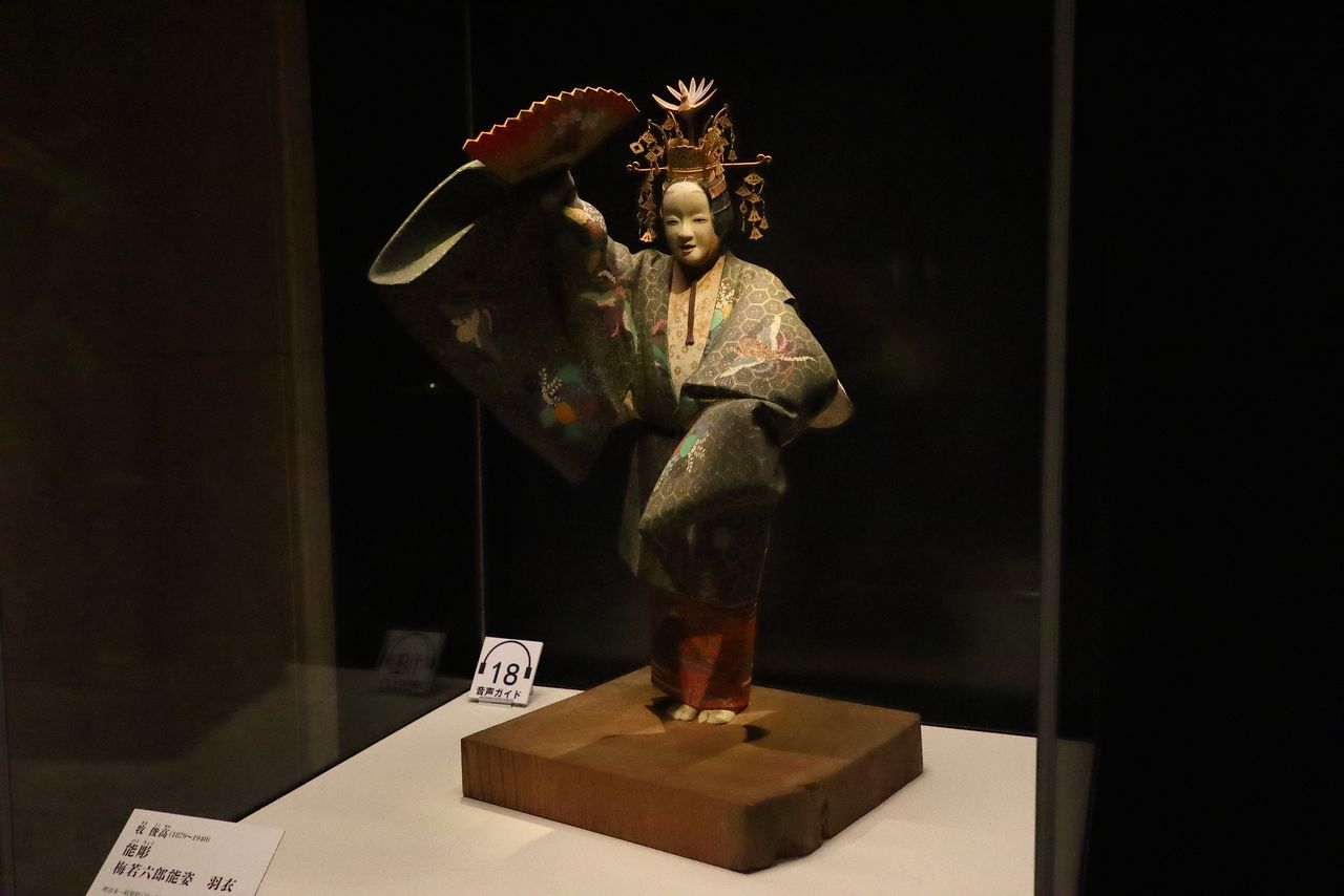 Doll of nō actor Umewaka Rokurō in the play “Hagoromo.” The woodcarving by Maki Toshitaka is made from a single piece of wood, including the pedestal.