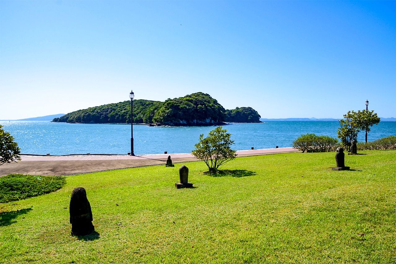 Koiji Island floats in Minamata Bay. Stone carvings on the shore stand in memorial to victims of Minamata Disease. The city has a museum dedicated to the mercury poisoning disaster that garnered worldwide attention in the 1950s and 1960s, while the coast offers scenic views and thermal waters. (© Pixta)