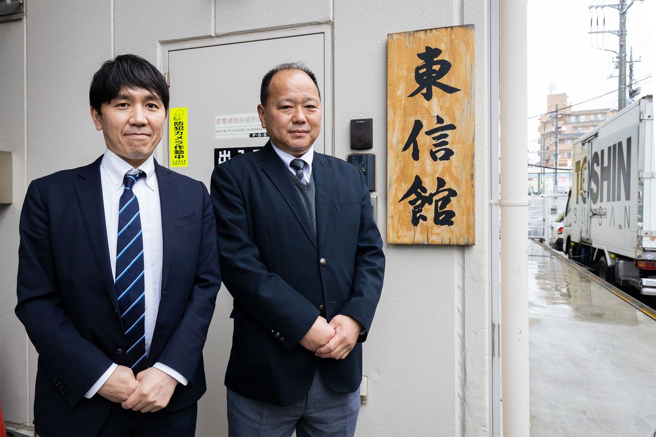 Public relations officer Takahashi Jun’ichi, left, and commercial department head Kosuge Masamitsu outside the Tōshinkan near the company’s Ogikubo main store.