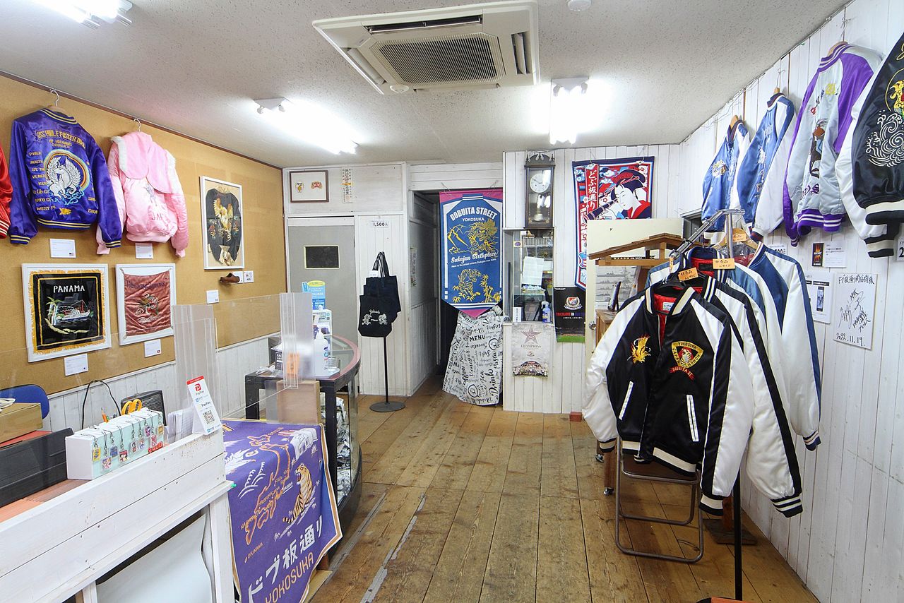 Vintage sukajan and jackets designed by Hitomoto and Yokochi on display at Dobuita Street Station adjacent to Mikasa.