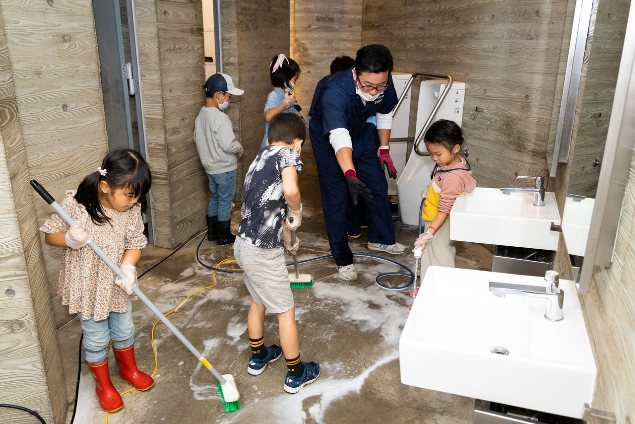 Children scrub the floor at the Ebisu Park Toilet in October 2022.