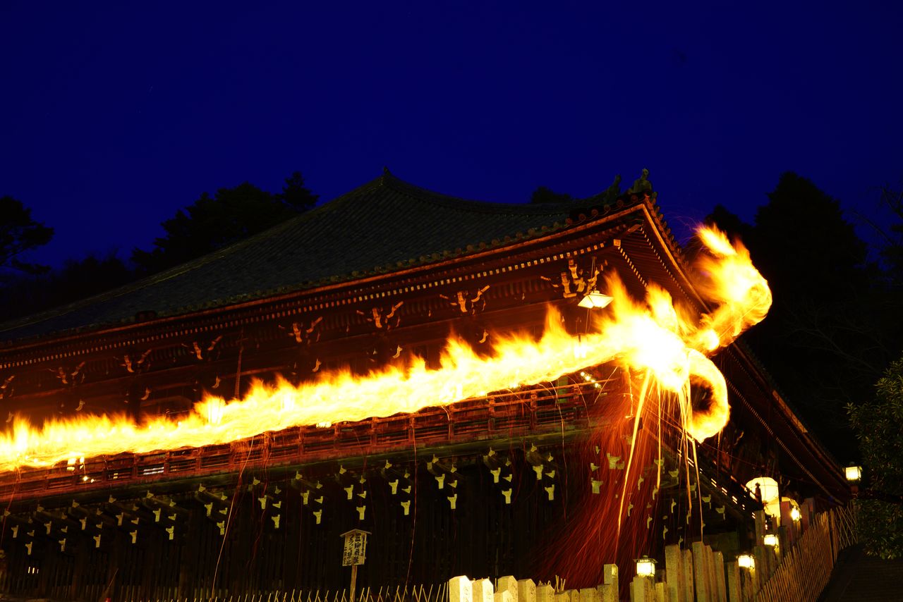 Priests swing pine torches along the balcony of the Nigatsudō in a rite known as Omizutori (literally “the drawing of water”), part of the Shunie ceremony held from March 1 to 14 each year. (© Pixta)