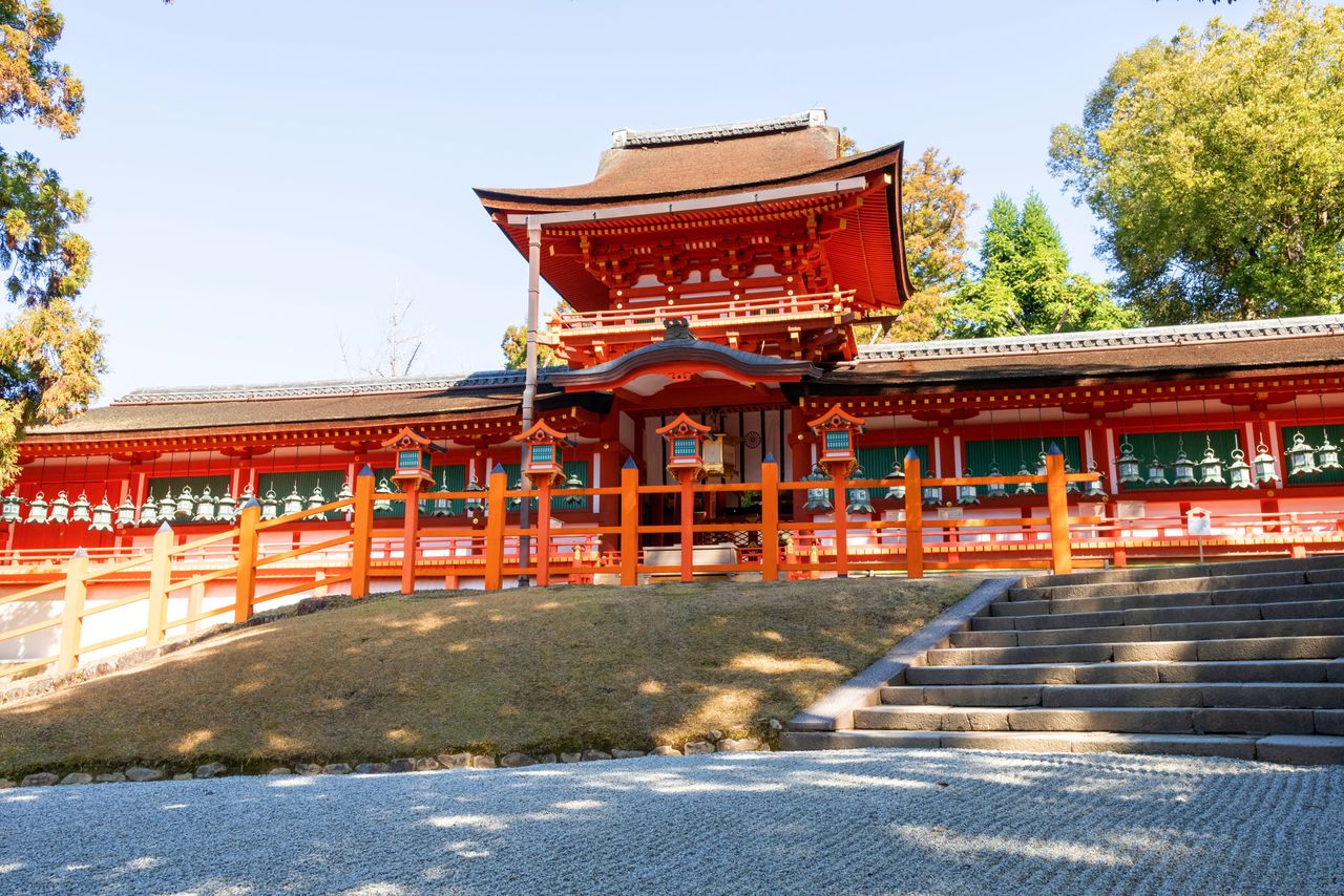 The shrine’s Chūmon, or “middle gate,” has 13-meter-long corridors extending to the left and right that are designated important cultural properties. Worshippers pray in front of the gate, which leads to the shrine’s honden (main hall) beyond.