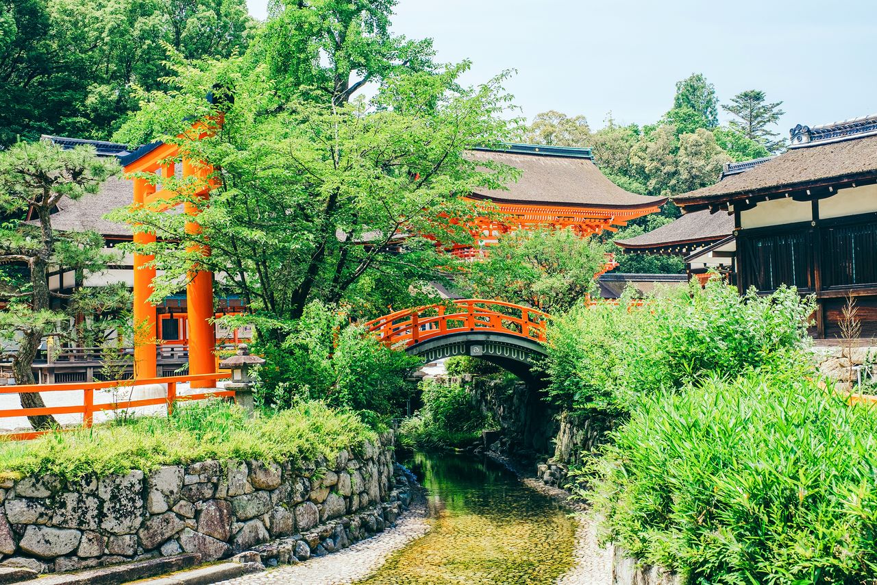 This vermillion arched bridge marks the site of Mitarashi Pond, to the right of the shrine’s main hall. (© Pixta)