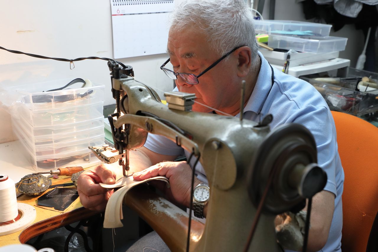 Some of the veteran artisans still use foot-operated treadle sewing machines. (© Hanai Tomoko)