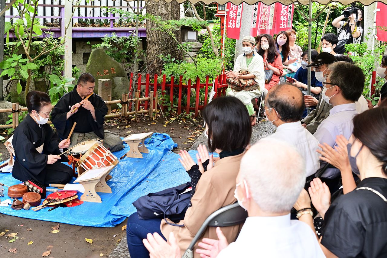 Many people attended the ceremony to enjoy a performance offered as part of the service. In the photo are traditional storyteller Mochizuki Tazae and a member of his troupe. (© Kichiya)