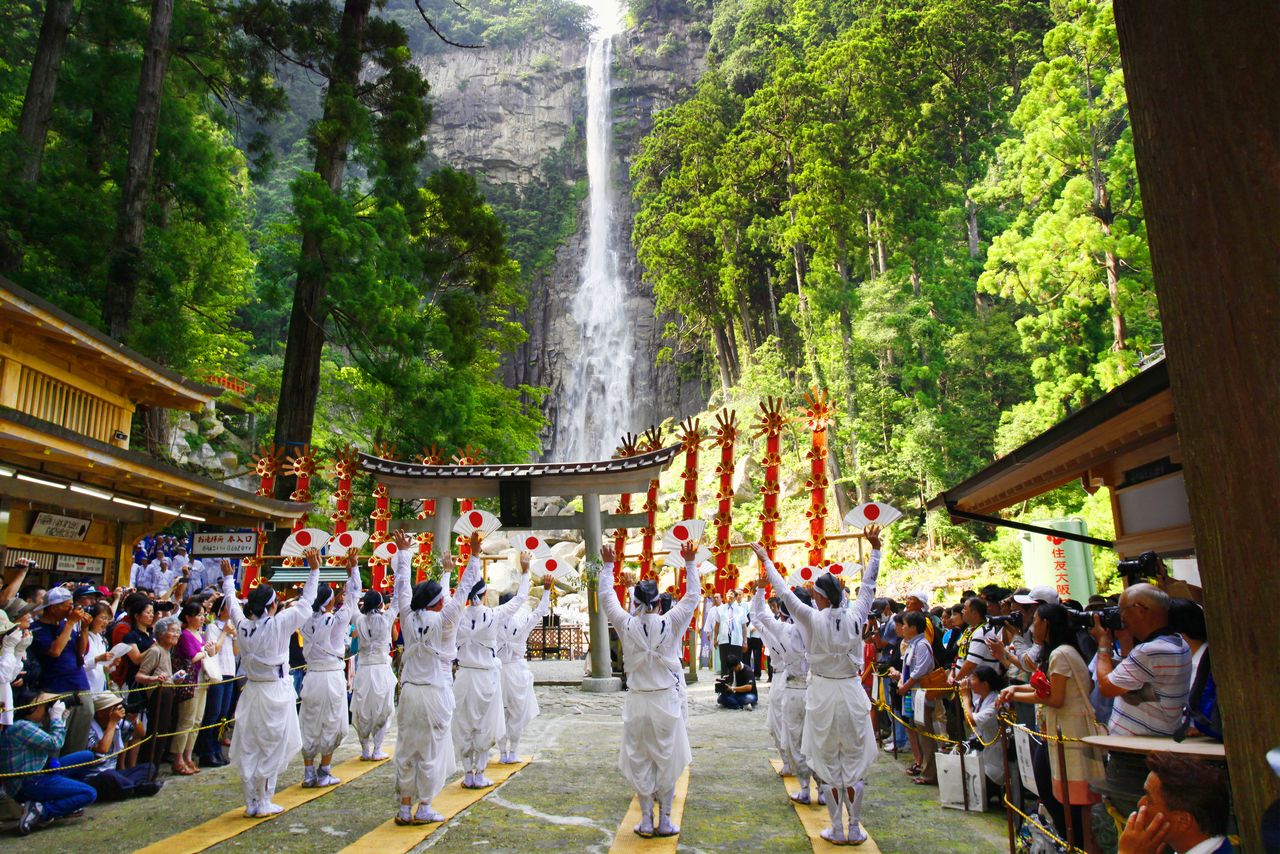 The 12 mikoshi, thin red boards six meters tall representing the falls, are gathered at the waterfall basin. (© Haga Library)