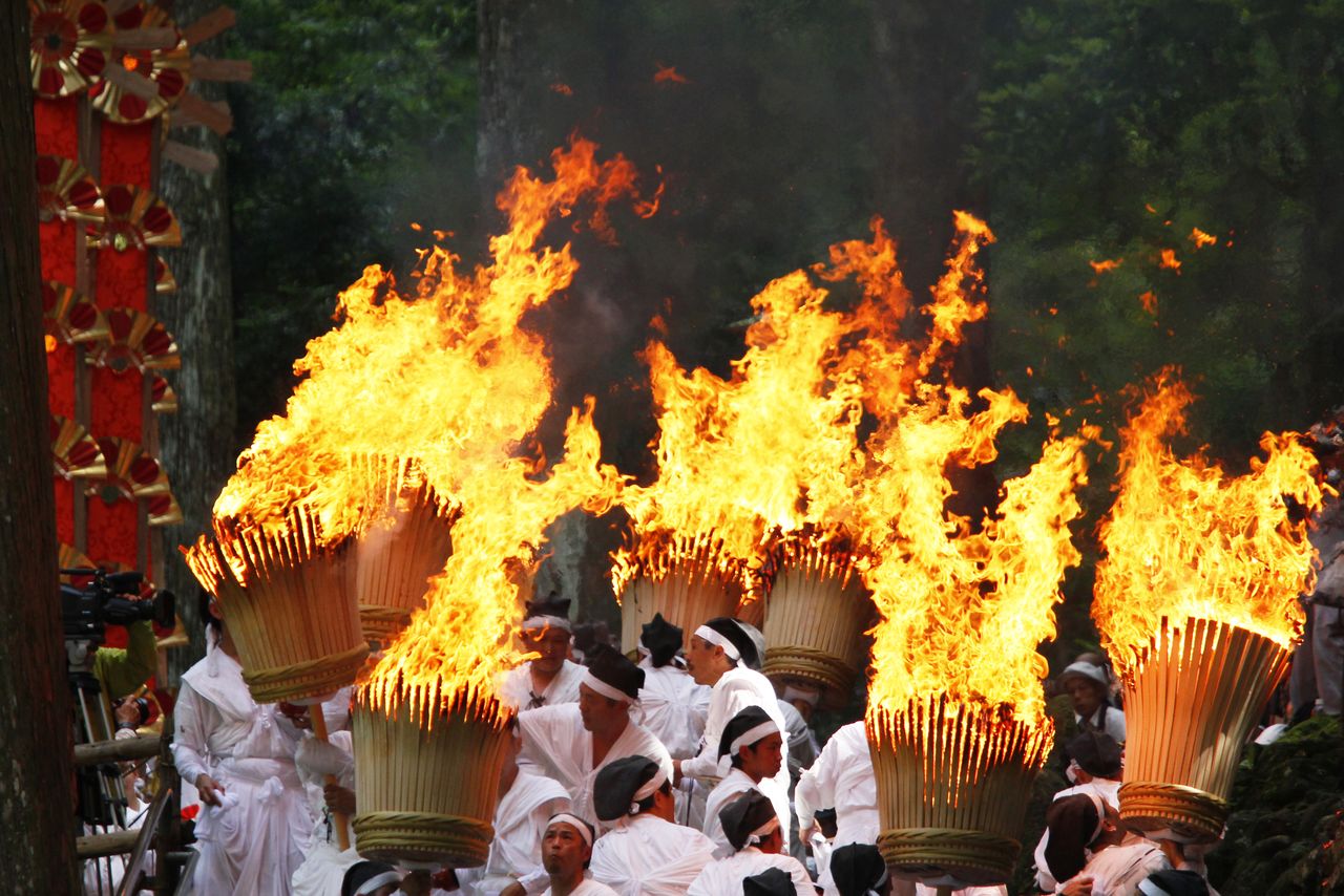 The flaming torches, fashioned from hinoki Japanese cypress and each weighing 50 kilograms, are an impressive sight. The event is also known as the Nachi Fire Festival. (© Haga Library)