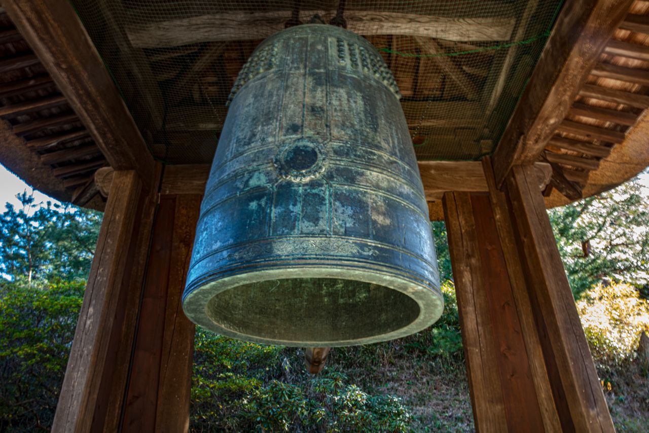 The thatched-roof belfry and its national treasure bell. (© Harada Hiroshi)
