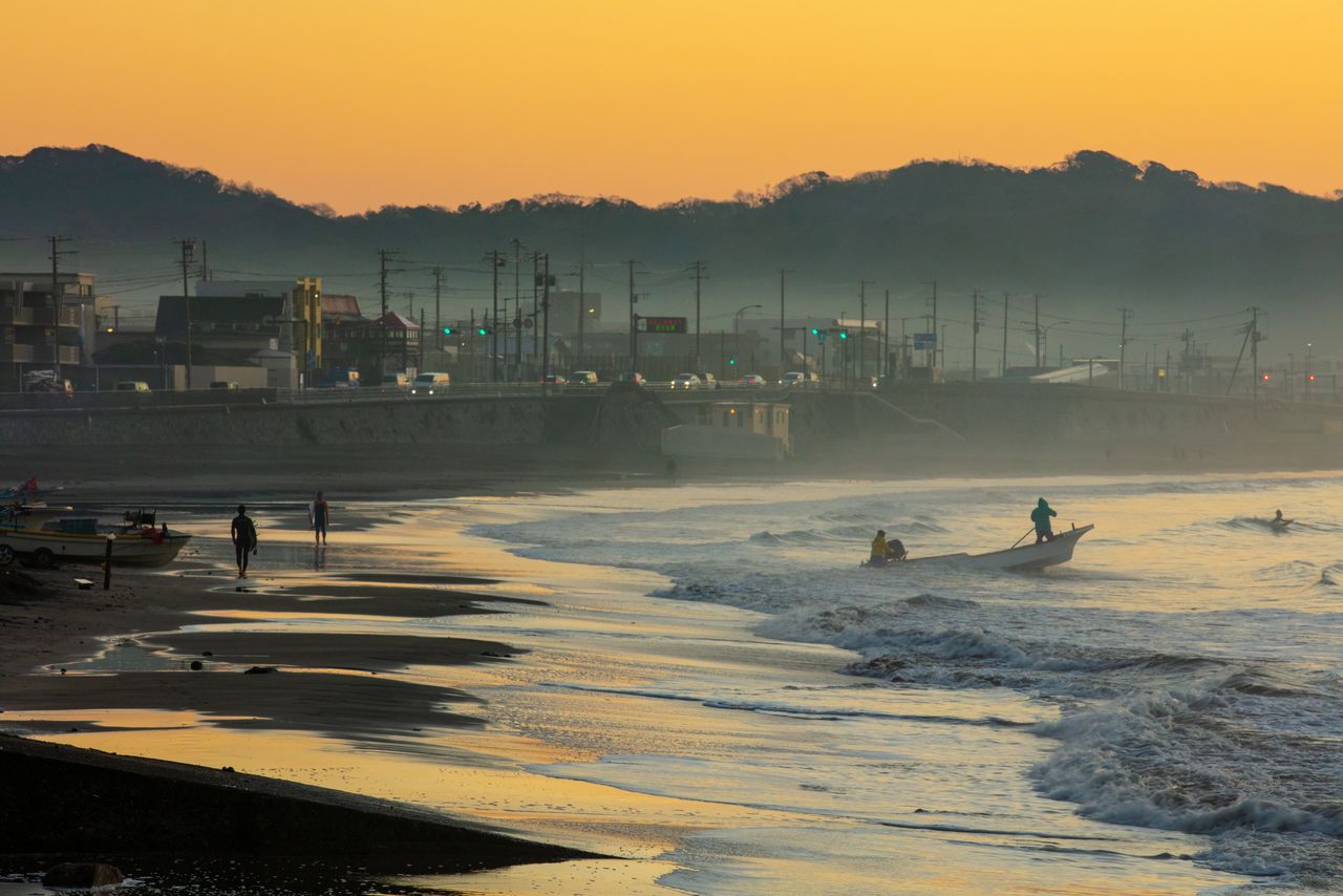 Fishers and surfers silhouetted at daybreak in Yuigahama. (© Harada Hiroshi)