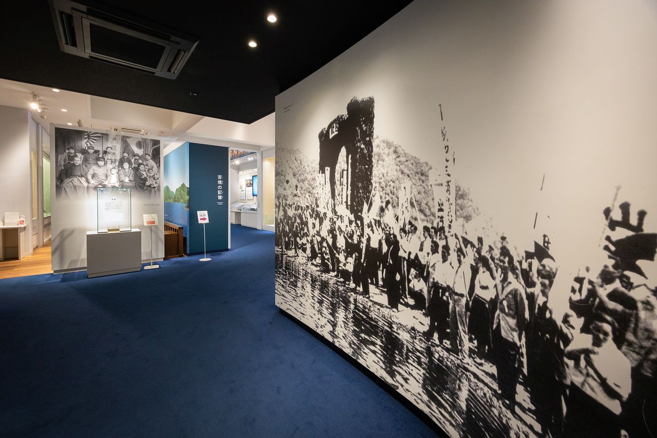 The photo at the entrance to the permanent exhibit, showing crowds waiting on the pier for the repatriated citizens, packs an emotional punch. (© Nippon.com)