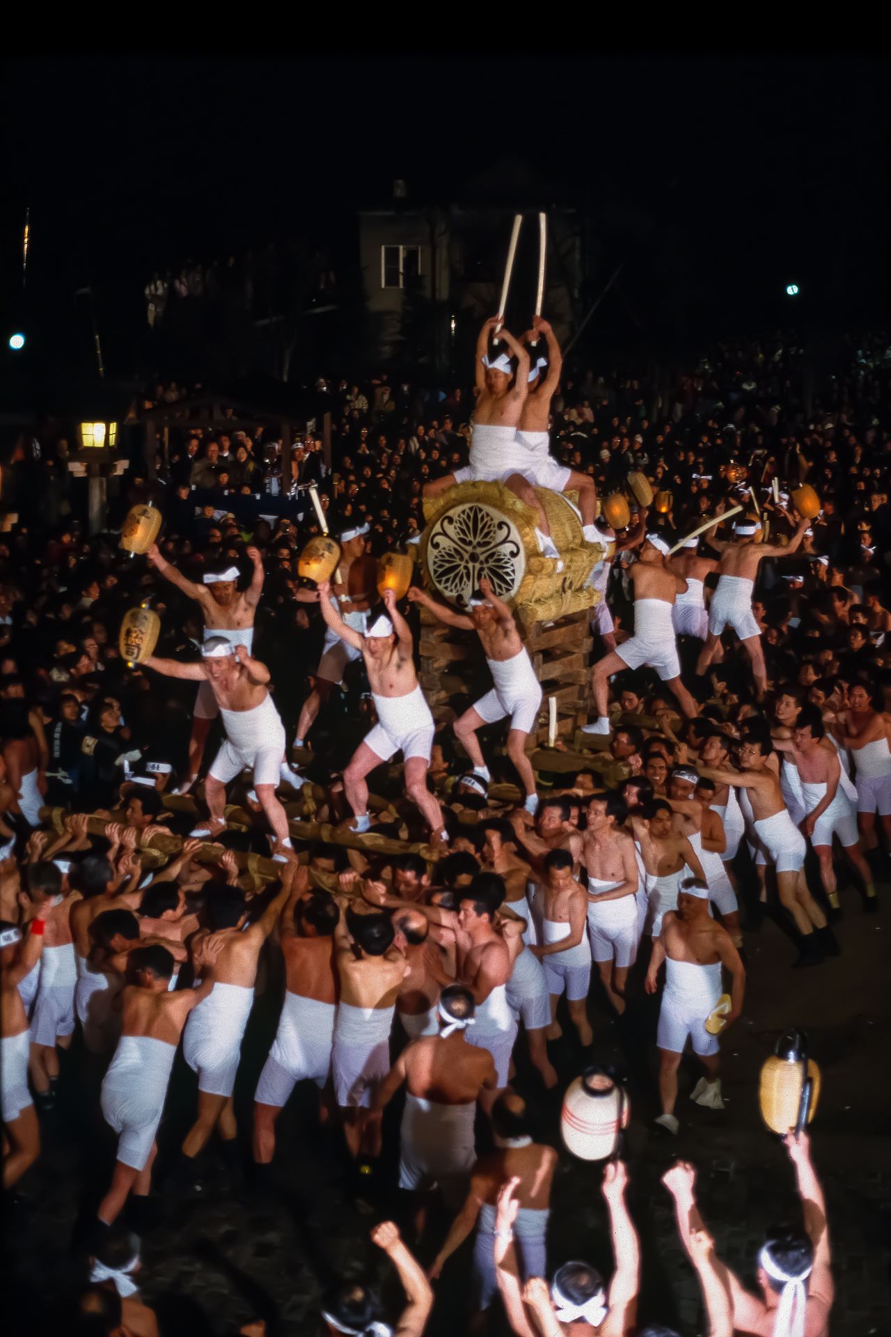 In the drum procession, bearers carry the huge drum, with two men astride and two others pounding out the matsuri rhythm. (© Haga Library)