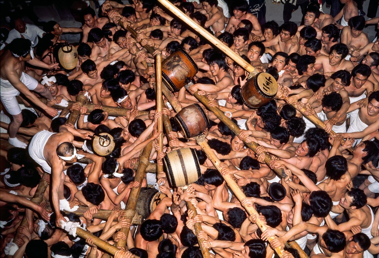 Men scramble over each other to approach the okoshidaiko. (© Haga Library)
