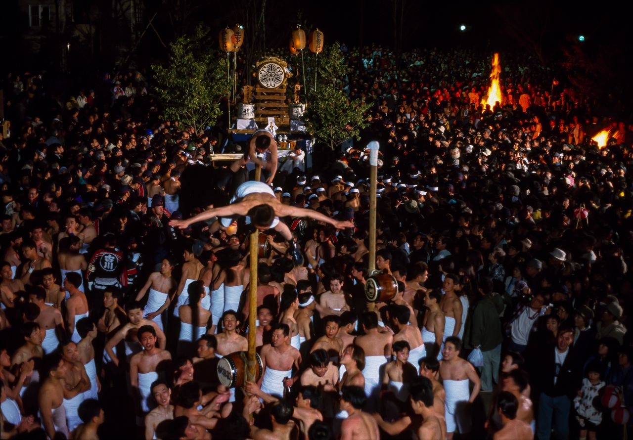 Festival participants perform an acrobatic “dragonfly” pose. (© Haga Library)