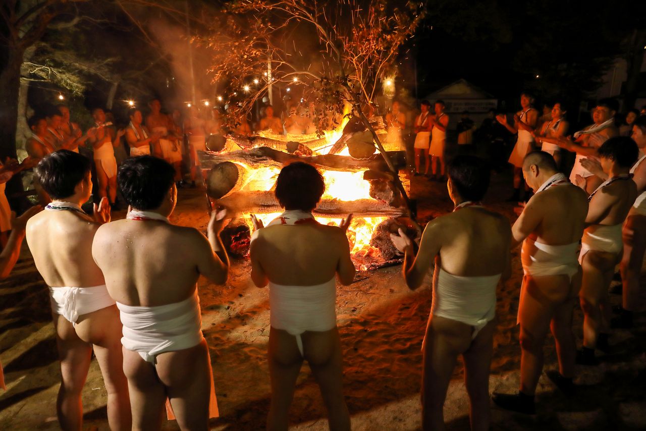 The men circle the bonfire in the finale to an exciting festival. (© Haga Library)
