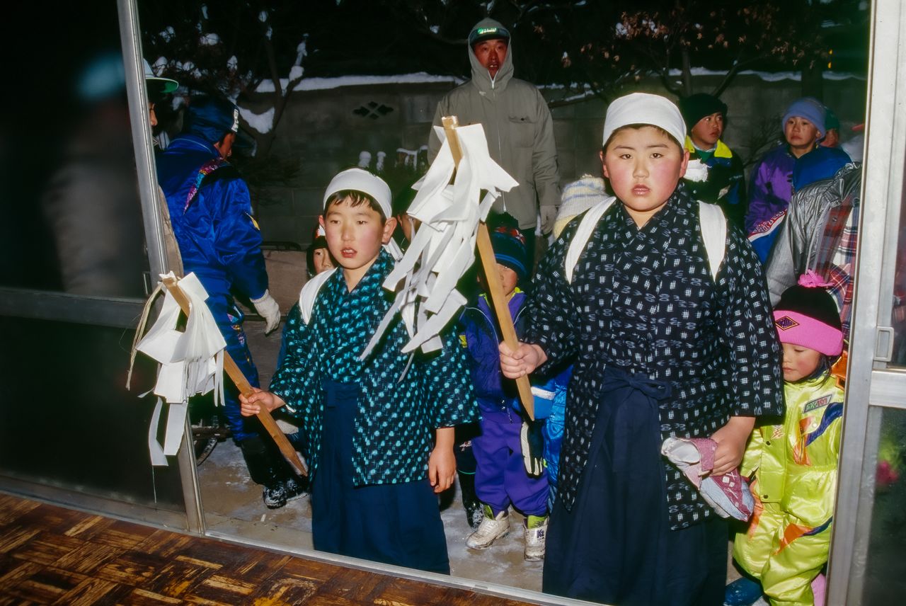 The boys are outfitted in traditional wear, including kasuri (ikat, a form of tie-dying seen across much of Asia) kimono and straw sandals. (© Haga Library)
