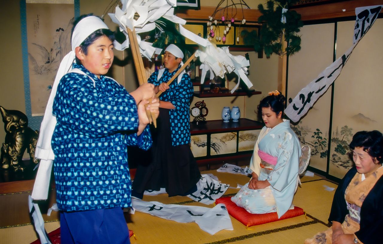 Part of the celebration involves waving the gohei staff to knock down kakizome, papers on which the first calligraphy of the year has been written. (© Haga Library)