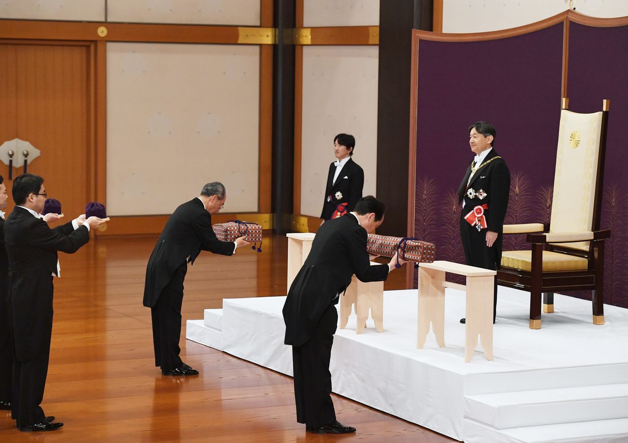 The sacred sword and jewels appear in boxes during a ceremony that is part of the imperial succession when Emperor Naruhito, at right, ascends to the throne on May 1, 2019. (© Jiji; pool photo)