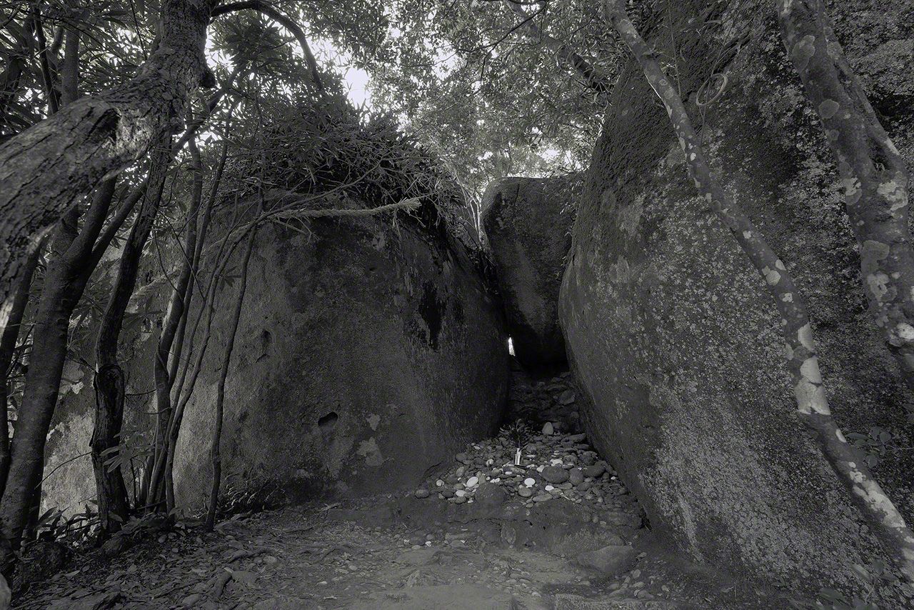 A narrow crevice beneath the boulder, believed to have served as a ritual space before the construction of the shrine. (&copy;&nbsp;Ōsaka Hiroshi)