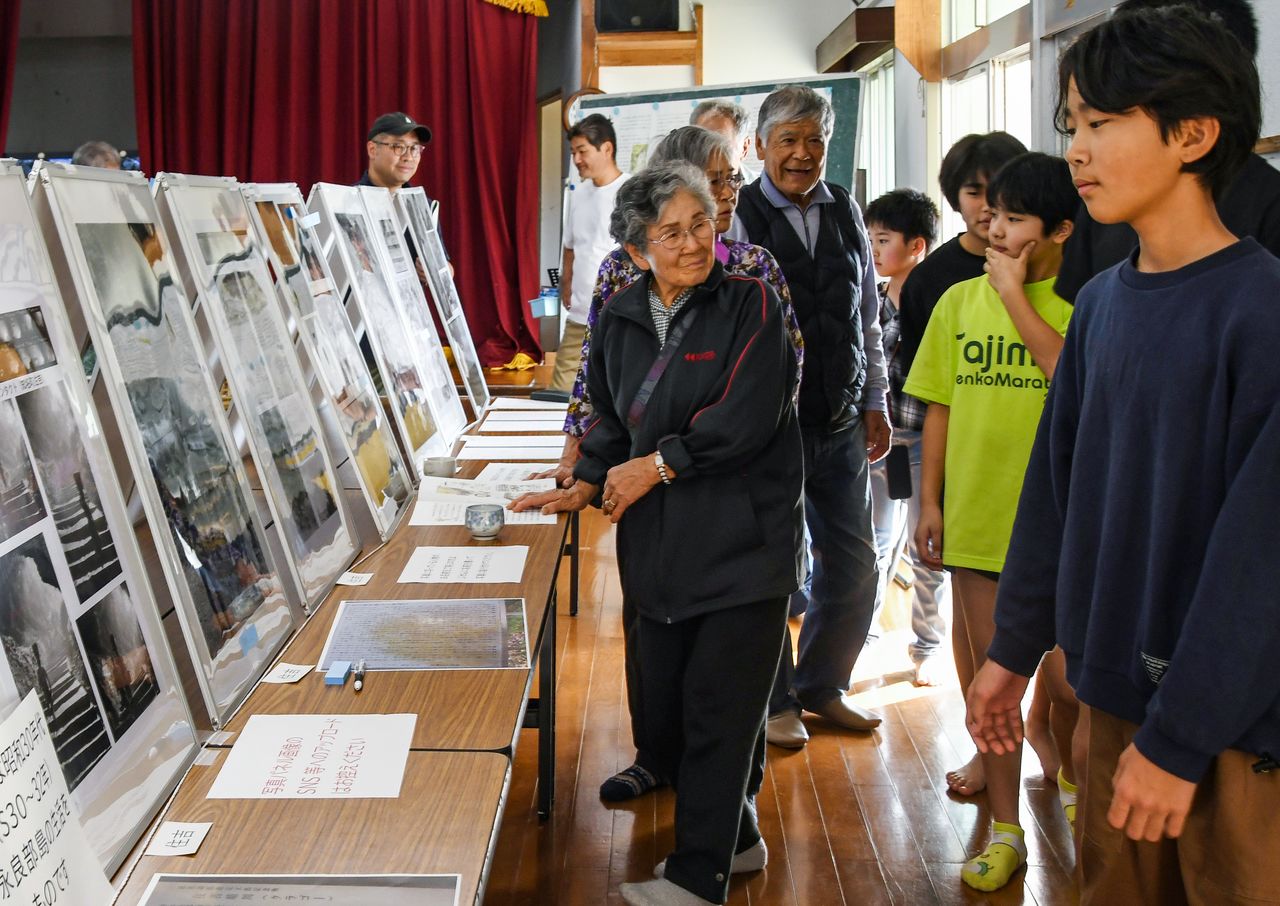 An elderly woman describes the photos to children in the Sumiyoshi district of China. (© Sakae Makiko)