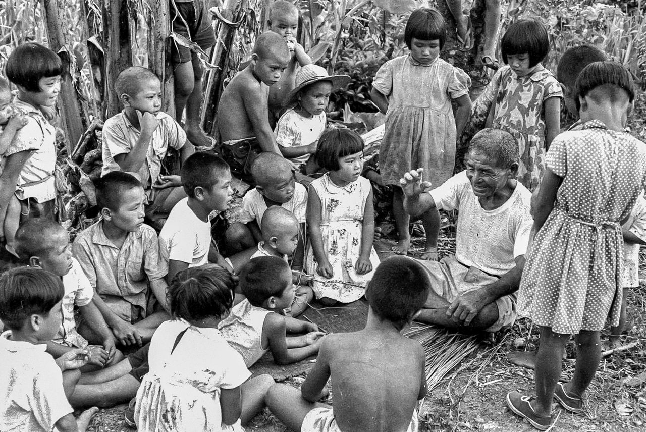 A storyteller shares mungatai folk tales on Okinoerabujima. The tales have been recorded in writing, but successors to the oral tradition rely on memory to reproduce the storyteller’s intonation and accent. (© Haga Hideo)