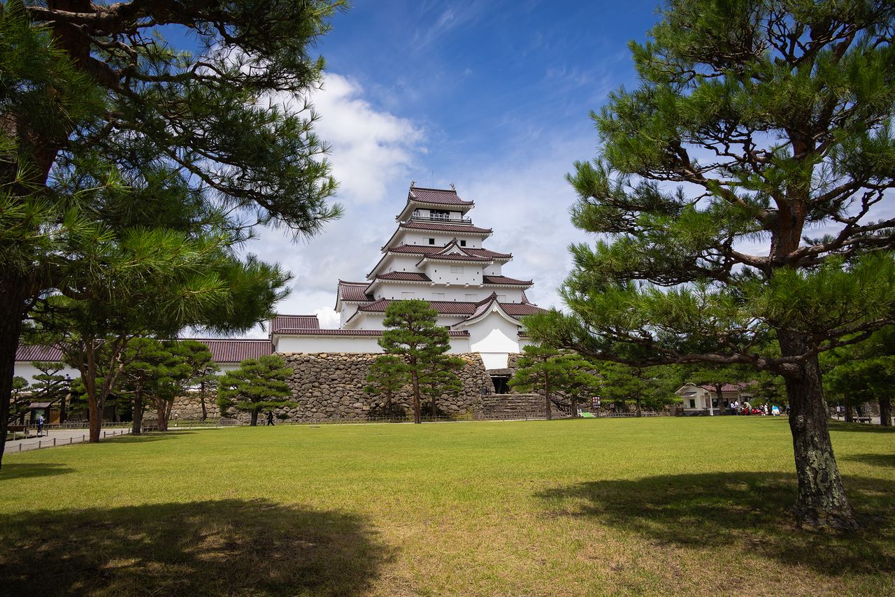Sweeping views of green lawns and pine trees in the park on the castle grounds. (© Nippon.com)