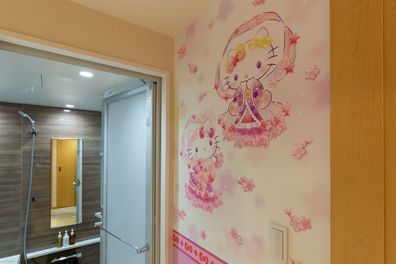 A Hello Kitty tennyo floats on the wall above the bathroom sink.