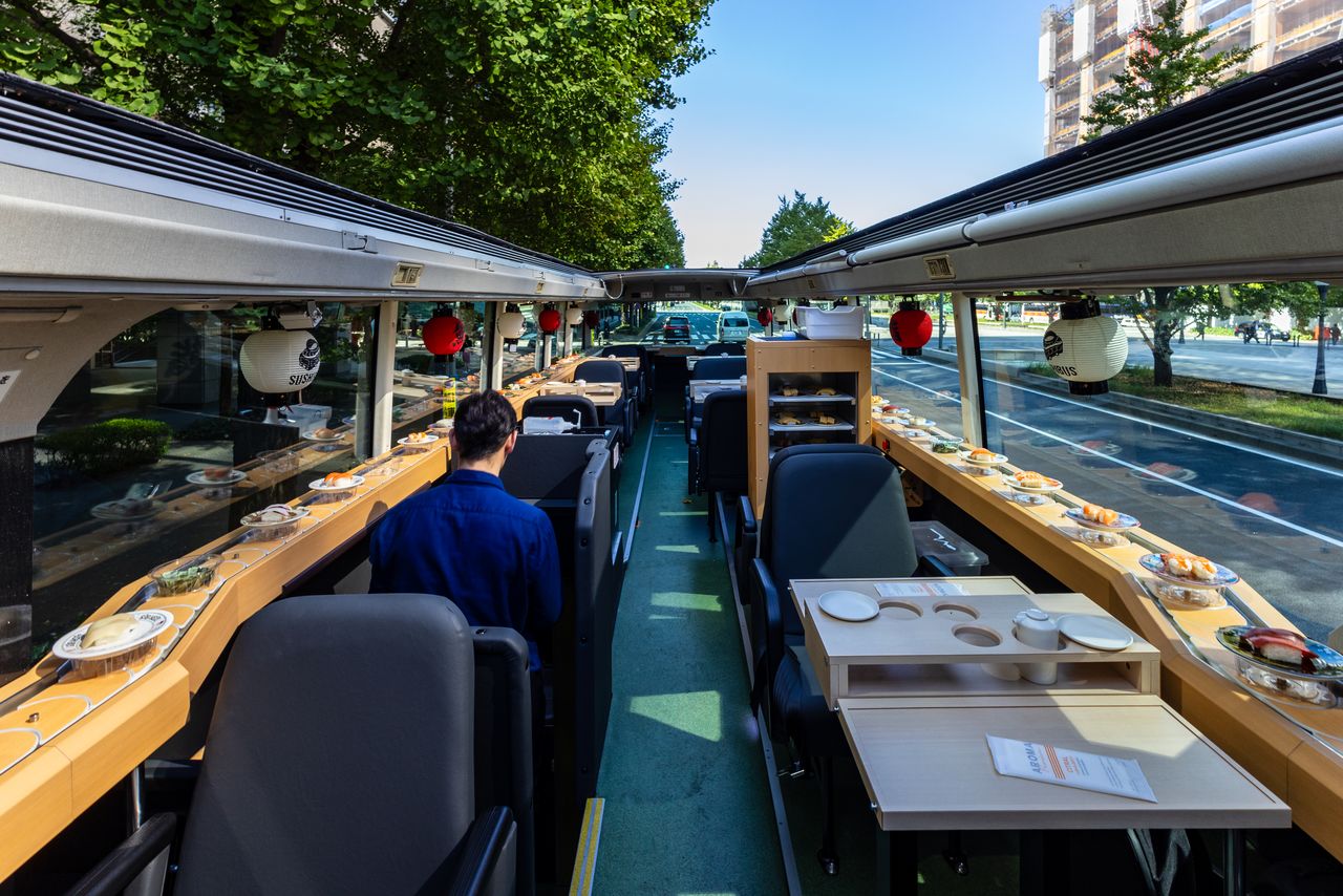 A rotating conveyor belt encircles the seating area. (© Nippon.com)