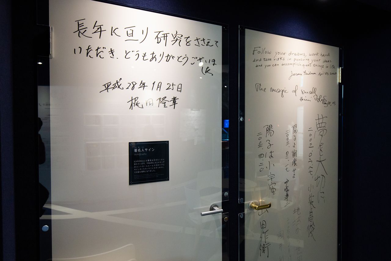 Autographs and messages from Kajita Takaaki, at left, and other prominent scientists.