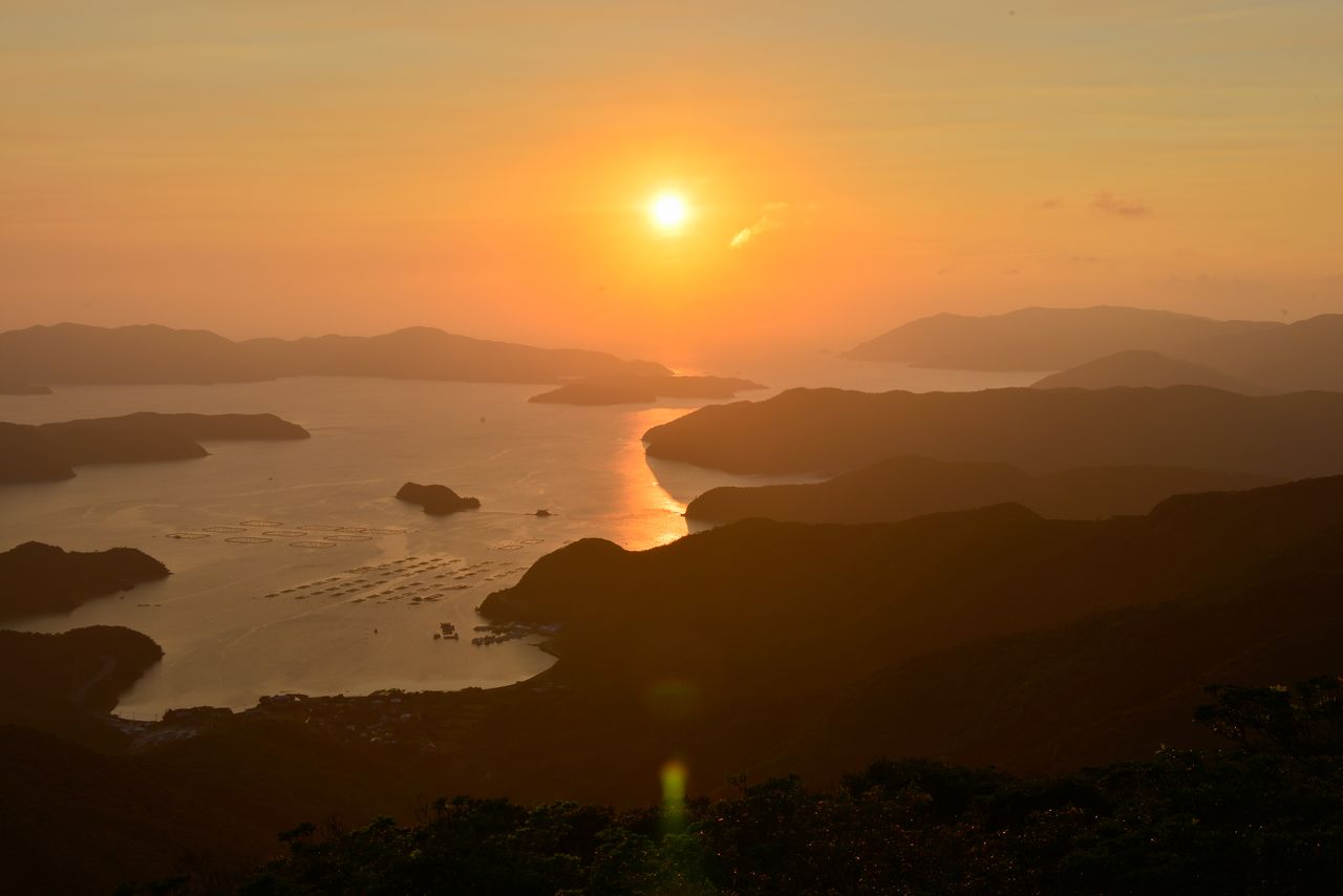 Sunset over the Ōshima Strait, in the direction of Kakeromajima. (© Pixta)