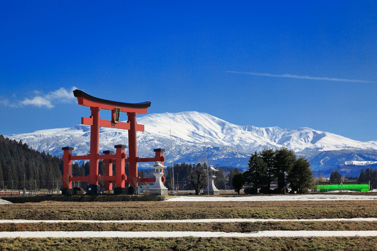 Mount Gassan, visible beyond Mount Haguro’s torii shrine gate. (© Pixta)